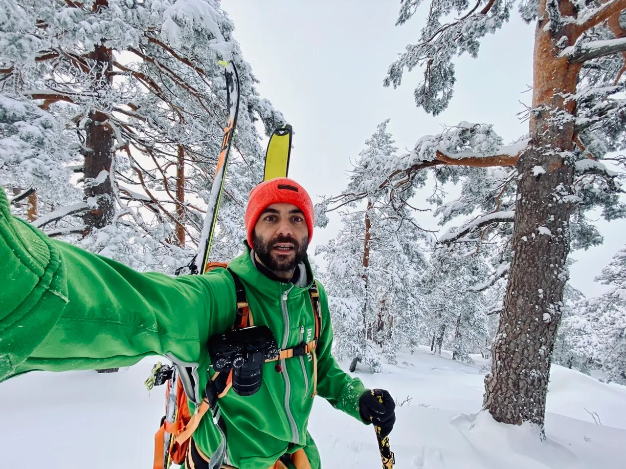 Javi ski touring in a snowy pine forest, camera on his chest